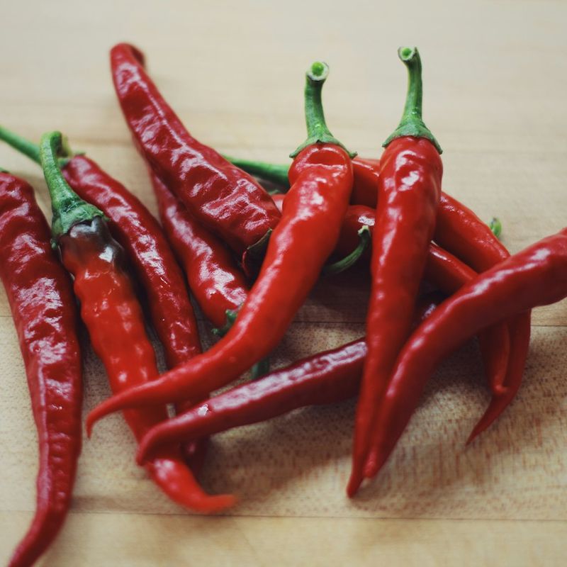 Rode chilipepers op een houten snijplank